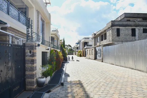 Street view of Crimson Bay villas with perimeter walls and gates
