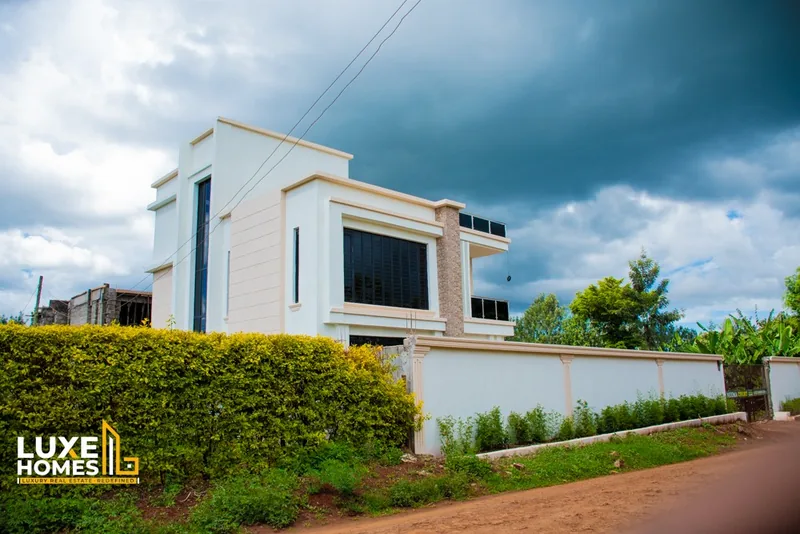 Side view of a Neema Court home with hedge and perimeter wall in Ruiru–Mugutha